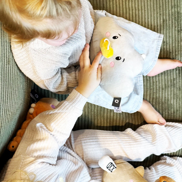 Kleinkind kuschelt mit Lenabie Lina (Wolke) auf dem Sofa – weiches Audio-Kuscheltier für Geschichten und Musik, kompatibel mit dem Lenabo Smart Speaker, ideal für ruhige Kuschelmomente zuhause